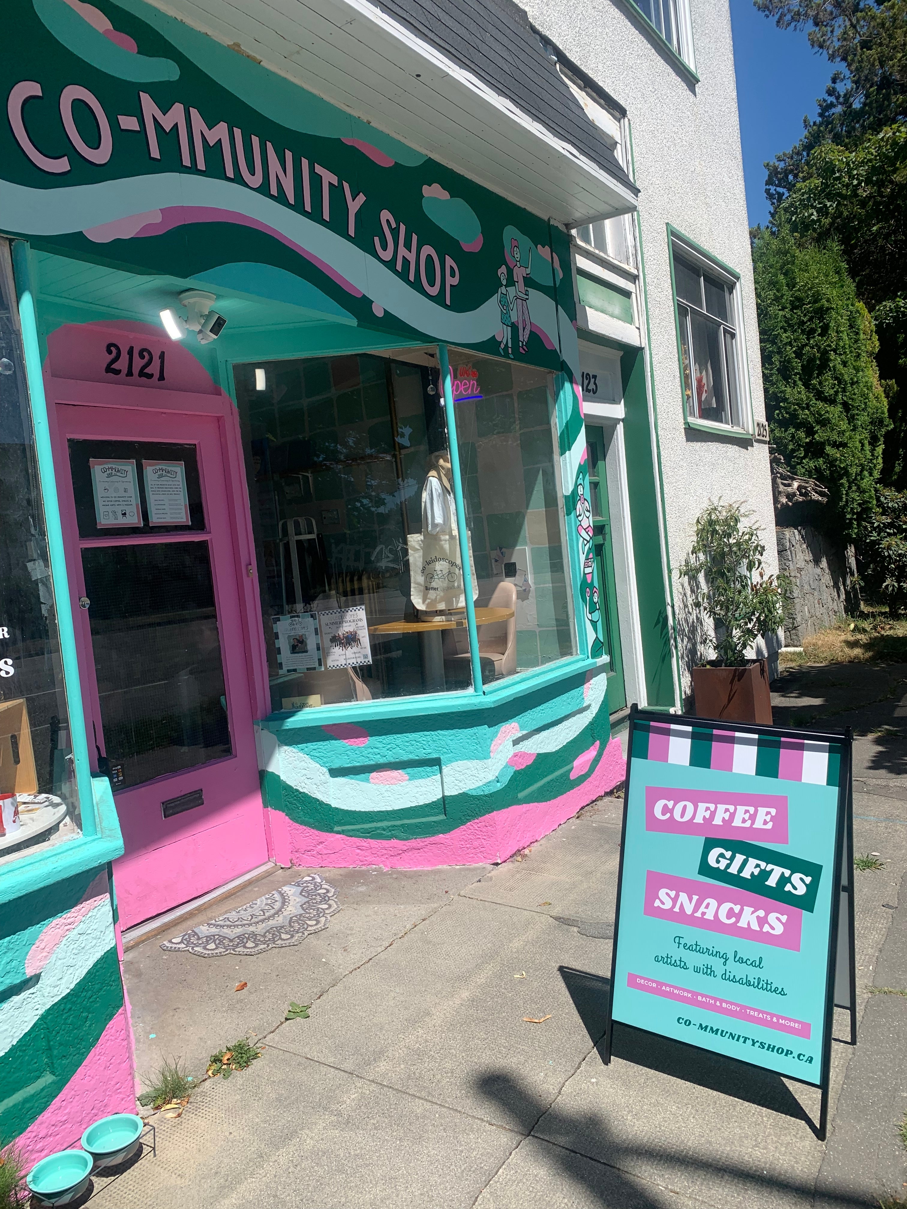 Colorful storefront with a sign advertising coffee, gifts, and snacks.