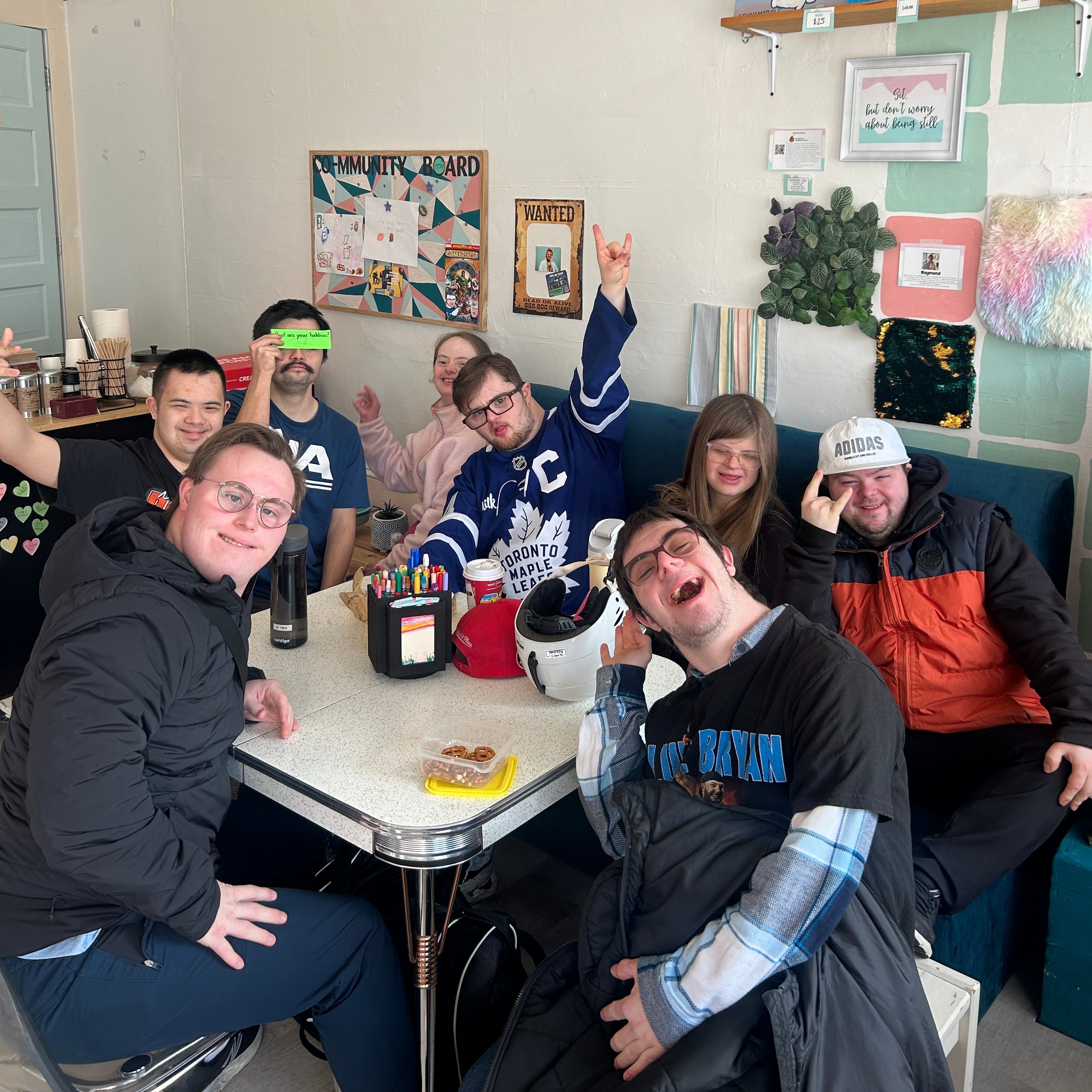 Group of people posing together in a casual indoor setting with a table and decor.